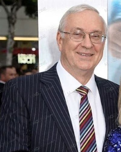 lose-up portrait of Colin Cavill, Henry Cavill's father and former stockbroker, wearing a suit and glasses.