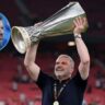 Ange Postecoglou celebrating with a football trophy after a major win, symbolizing success and leadership in 2025