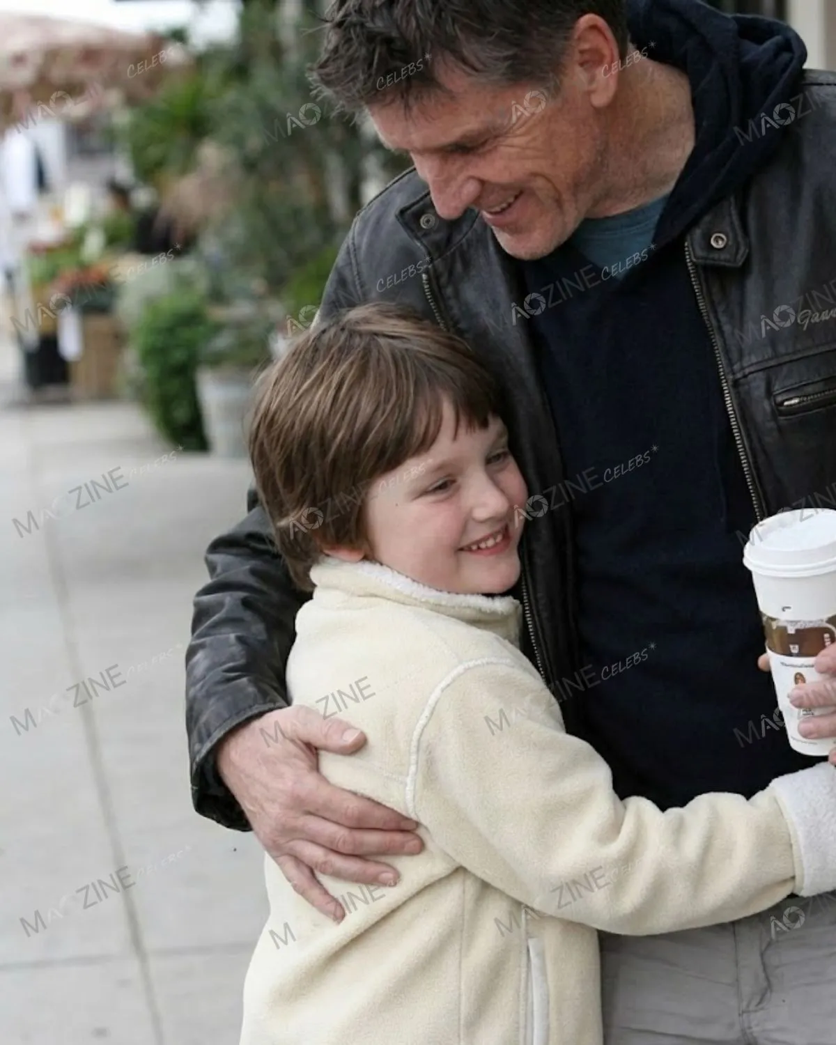 Close-up photo of Craig Ferguson smiling and hugging his young son Milo Hamish Ferguson.