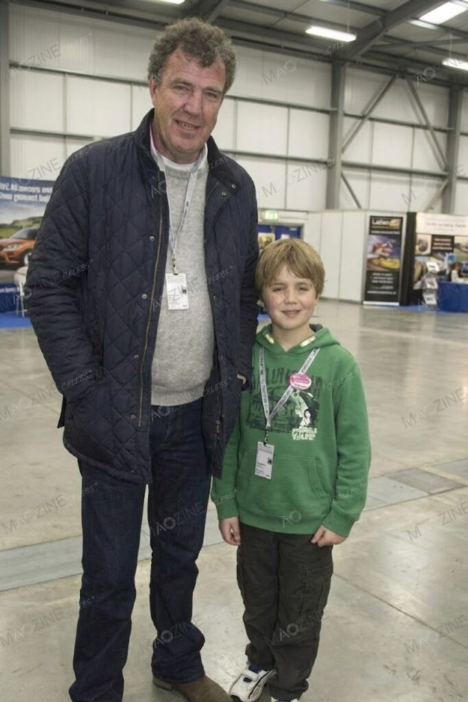 An older photograph showing a young Finlo Clarkson standing next to his father, Jeremy Clarkson, inside an exhibition hall.