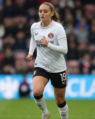 Ella Rutherford running on the football pitch wearing a white Charlton Athletic kit during a match.
