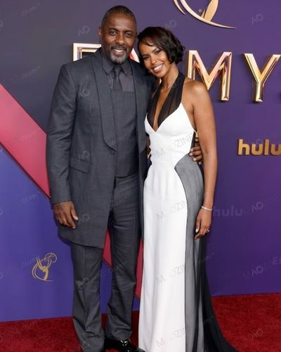 Idris Elba in a grey suit and wife Sabrina Dhowre Elba in a stunning black and white gown posing on the red carpet.