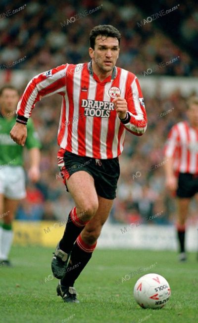 Neil Ruddock running on the pitch during a Southampton game wearing the classic Drapers Tools sponsored shirt.