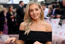 Amy Dowden smiling in a black off-shoulder dress at the National Television Awards (NTA) red carpet.