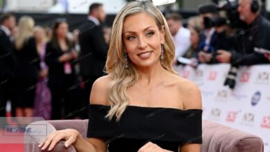 Amy Dowden smiling in a black off-shoulder dress at the National Television Awards (NTA) red carpet.