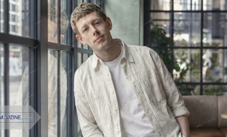 Josh Finan as Dan in BBC drama Waiting for the Out, wearing a striped shirt leaning against a window