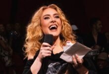 Adele holding a mic in her hand and singing a song.