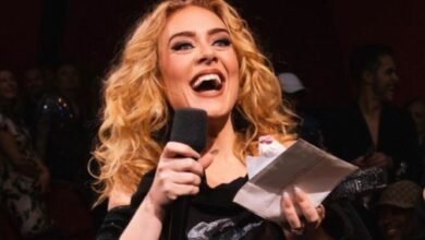 Adele holding a mic in her hand and singing a song.