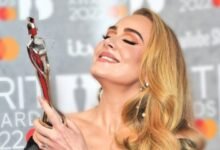 Adele holding a trophy in her hand | Adele Biography