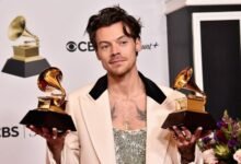 Harry Styles Net Worth | He is holding two trophies in his hand.