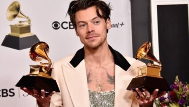 Harry Styles Net Worth | He is holding two trophies in his hand.